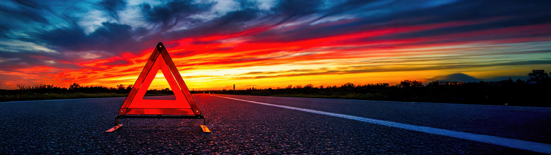 Warndreieck auf Autobahn im Sonnenuntergang